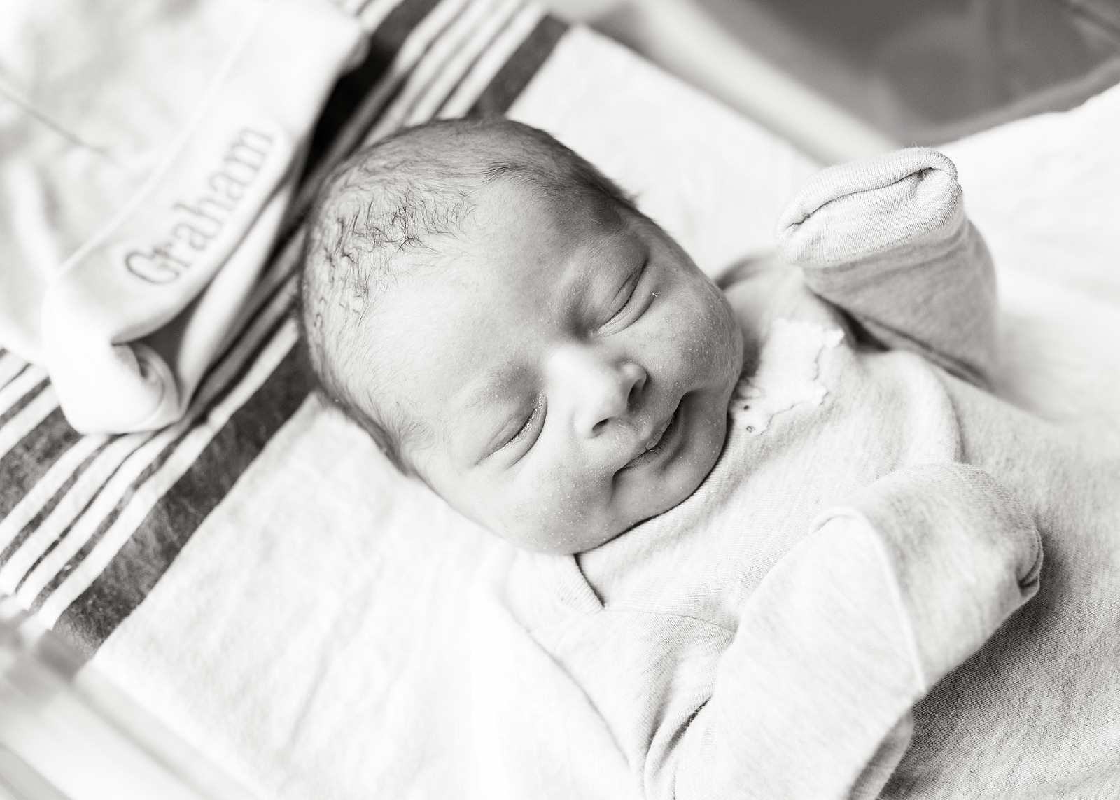 newborn baby lying in hospital cradle